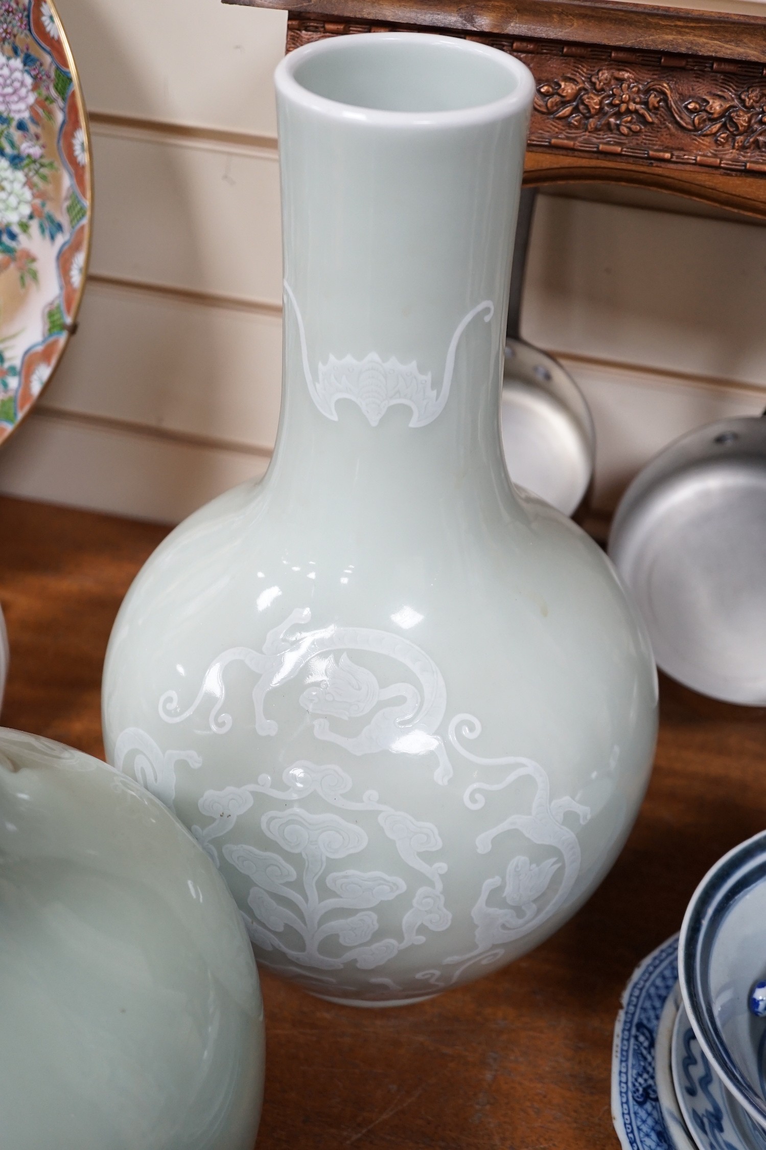 A pair of Chinese white slip decorated celadon glazed bottle vases, mid 20th century, 39cm